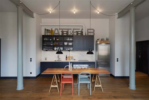 Cucina con pensili scuri e tavolo in rovere - esempi stile industriale